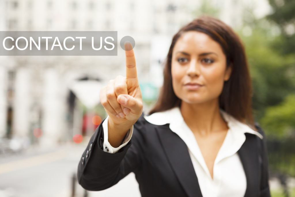 A young well dressed woman on a city street presses a virtual SUPPORT button suspended in mid-air. [url=/my_lightbox_contents.php?lightboxID=13637164]Click here for more[/url] from this shoot.